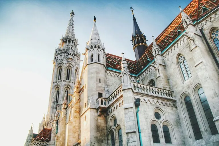 Captivating low angle view of Matthias Church in Budapest, showcasing gothic architecture against a clear sky.